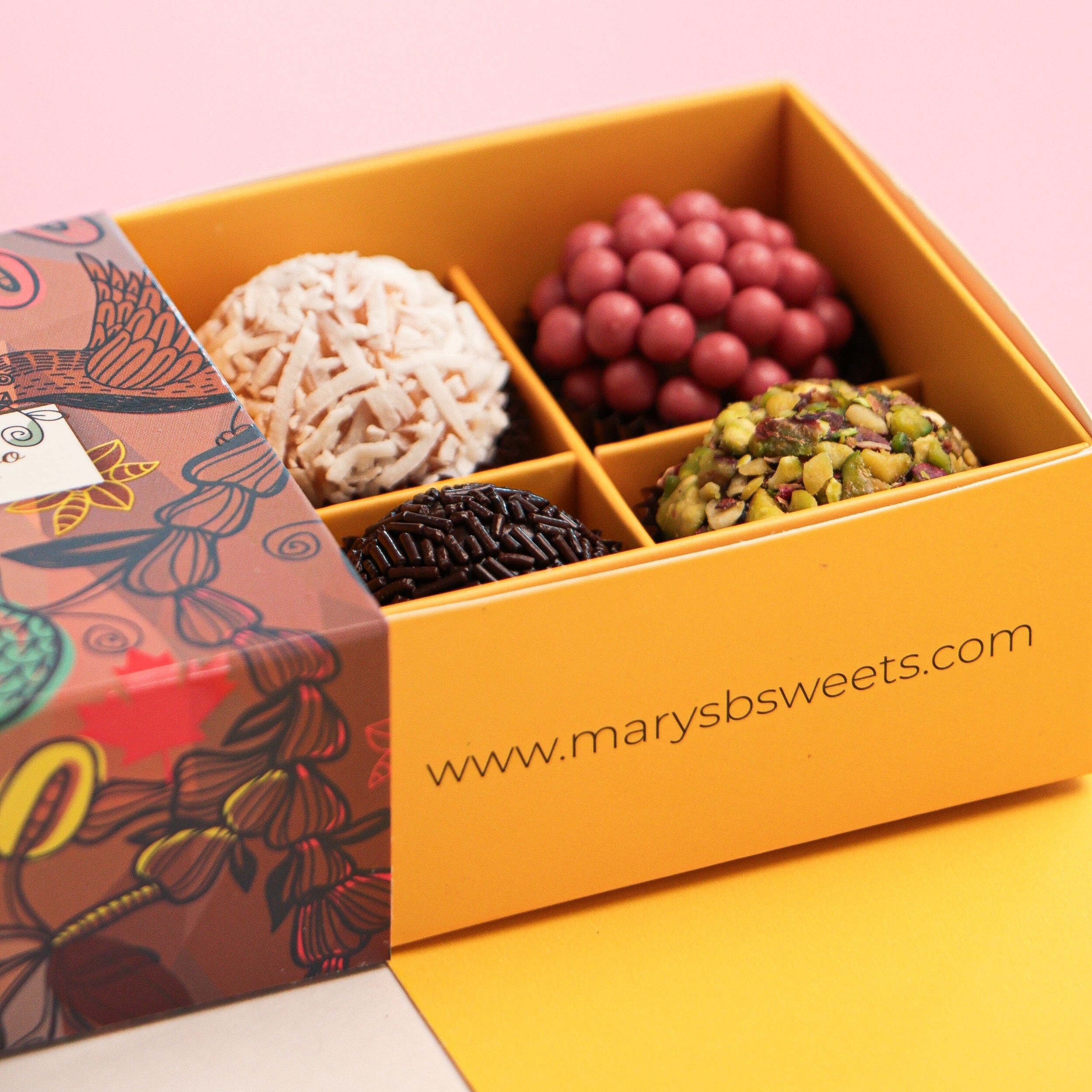 Box of assorted chocolates with a pink background and 'www.marysb sweets.com' branding.
